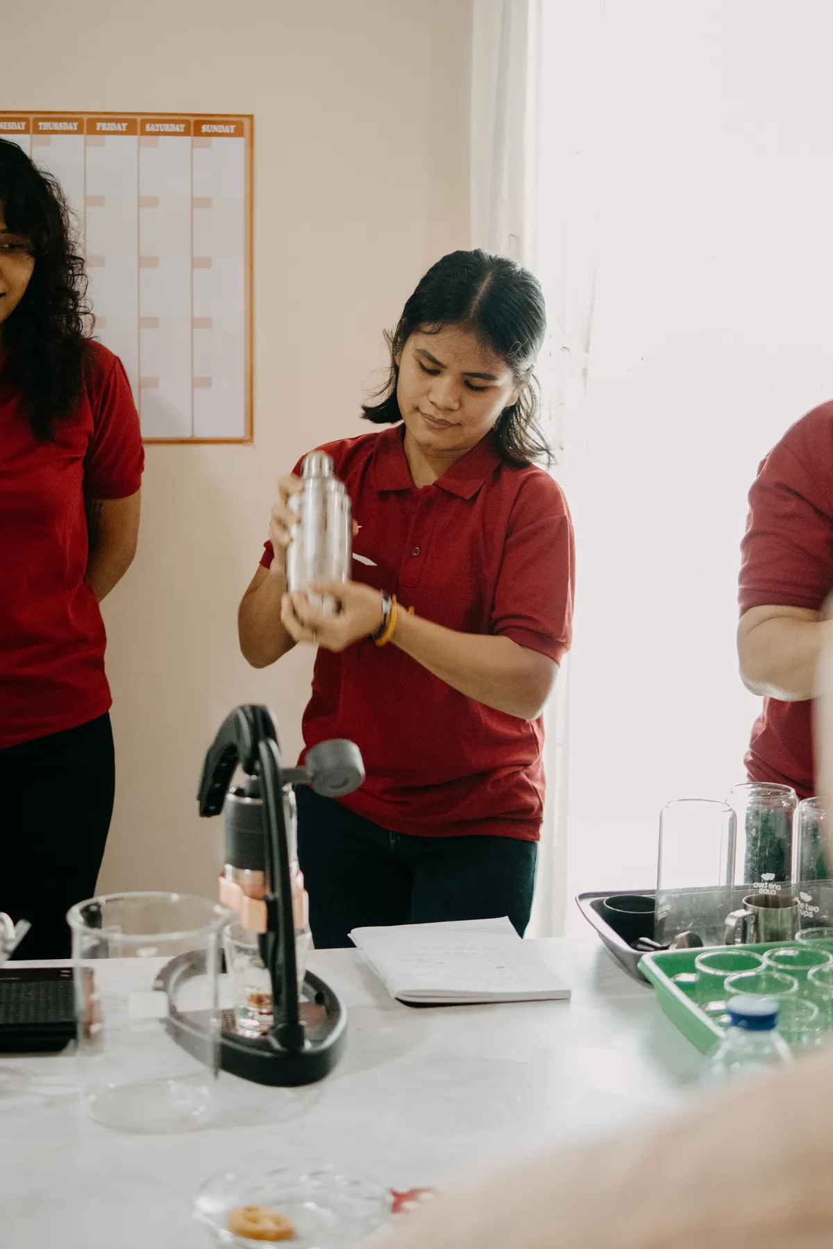 A member of the Kopi Suka Cita team shaking a cocktail shaker during tasting prep