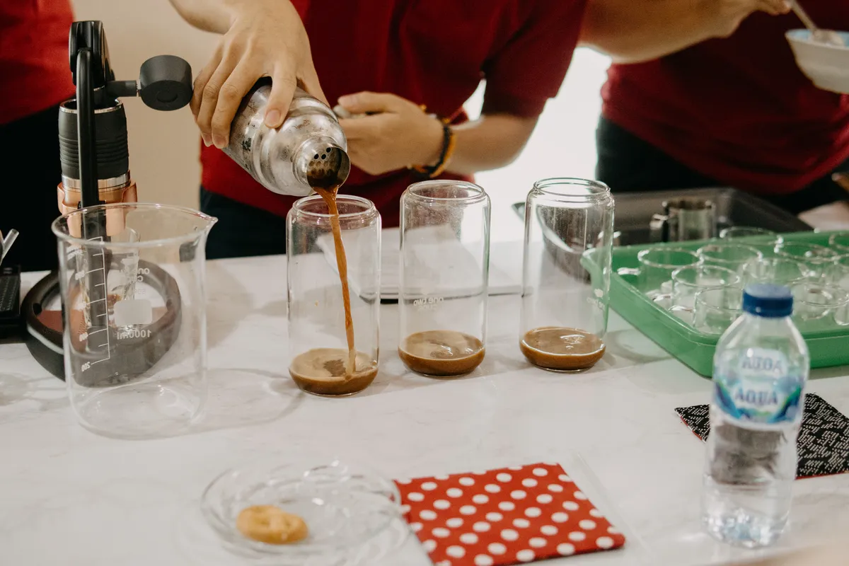 Kopi Suka Cita coffee being poured into cupping glasses during a tasting session