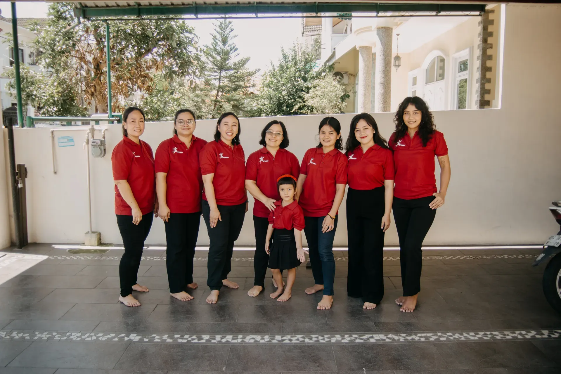 The women of the Kopi Suka Cita team together in their red uniforms